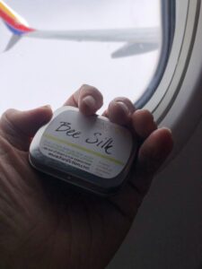 Beesilk hard lotion bar in hand on an airplane