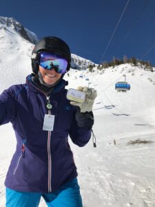 Woman holding a Beesilk Lotion Bar while skiing