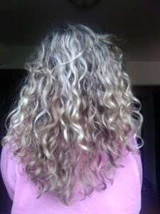 Back of woman's head showing curly long hair after using shampoo bar