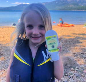 Little girl holding up sunscreen